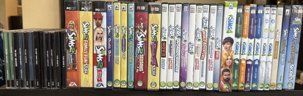 A row of Windows PC game boxes from The Sims series lined up on a shelf, varying colorful spines and EA logos visible.